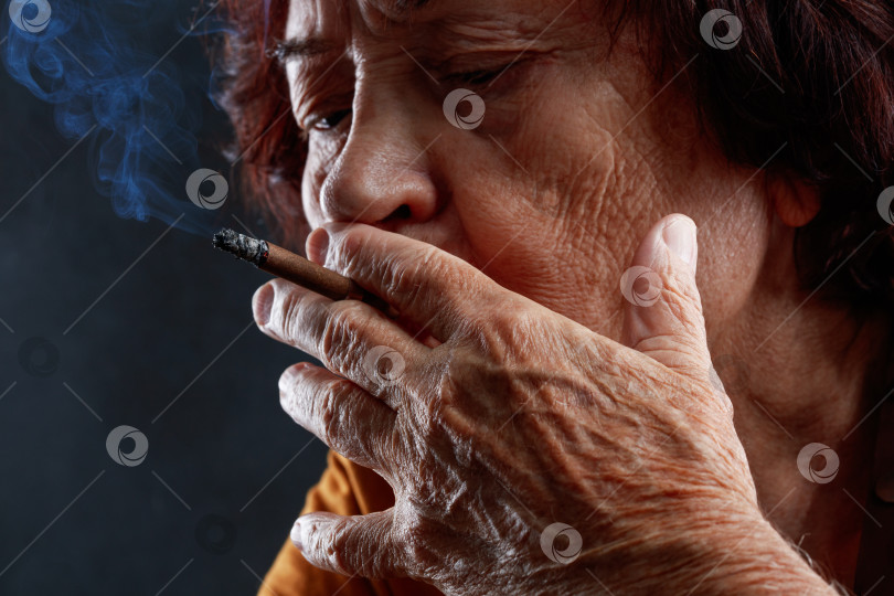 Скачать Крупным планом пожилая женщина курит сигарету. фотосток Ozero