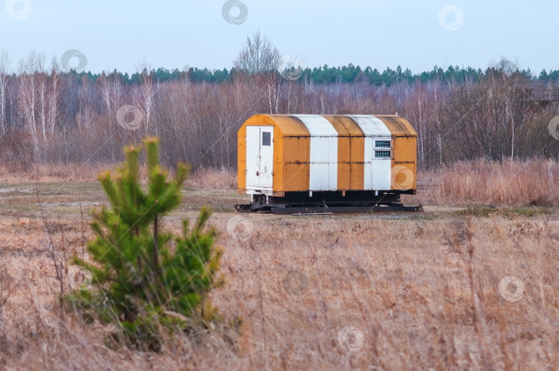 Скачать Полосатый домик-фургон на опушке леса рядом со взлетно-посадочной полосой аэродрома. фотосток Ozero