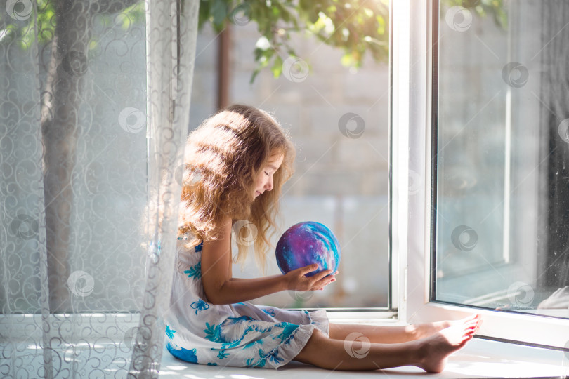 Скачать Девушка на окне дома держит лампу в форме планеты, глобуса. Мир, экология, окружающая среда, мирный фотосток Ozero