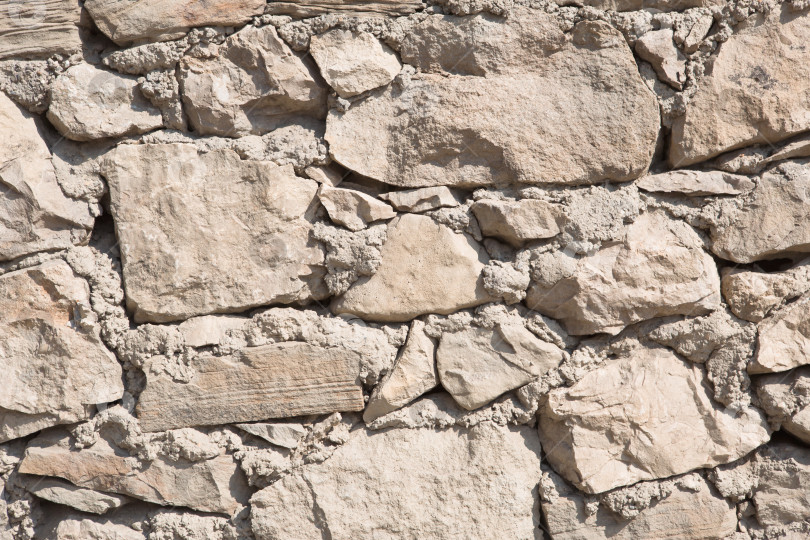 Скачать Кирпичная кладка стен натурального песочного цвета. Текстура камня крупным планом, фон строительства и добычи полезных ископаемых. фотосток Ozero