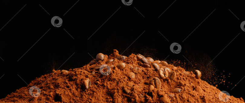 Скачать Падающие кофейные зерна в куче шоколадной пудры на деревянном столе. фотосток Ozero
