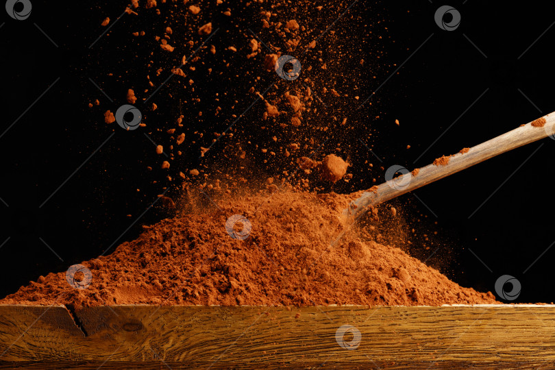 Скачать Посыпьте шоколадной пудрой деревянный стол и ложку. фотосток Ozero
