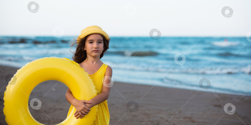 Скачать Девушка с желтым надувным кругом на берегу моря. Отдых на пляже, летние путешествия. фотосток Ozero