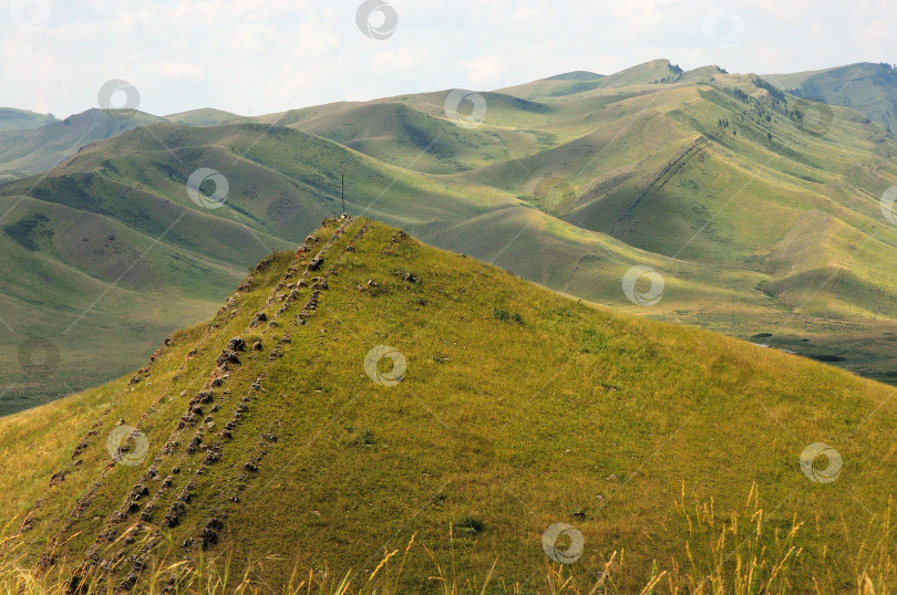 Скачать Вид с вершины длинного горного хребта с параллельными рядами каменистых образований, идущих вдоль вершин. фотосток Ozero