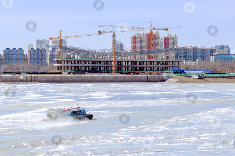 Скачать Большая строительная площадка на берегу реки Амур зимой. Строительство международного терминала канатной дороги между Россией и Китаем. фотосток Ozero