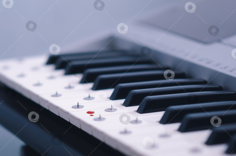 Скачать Кнопки лежат на клавишах электронного синтезатора. Размытые капли крови. фотосток Ozero
