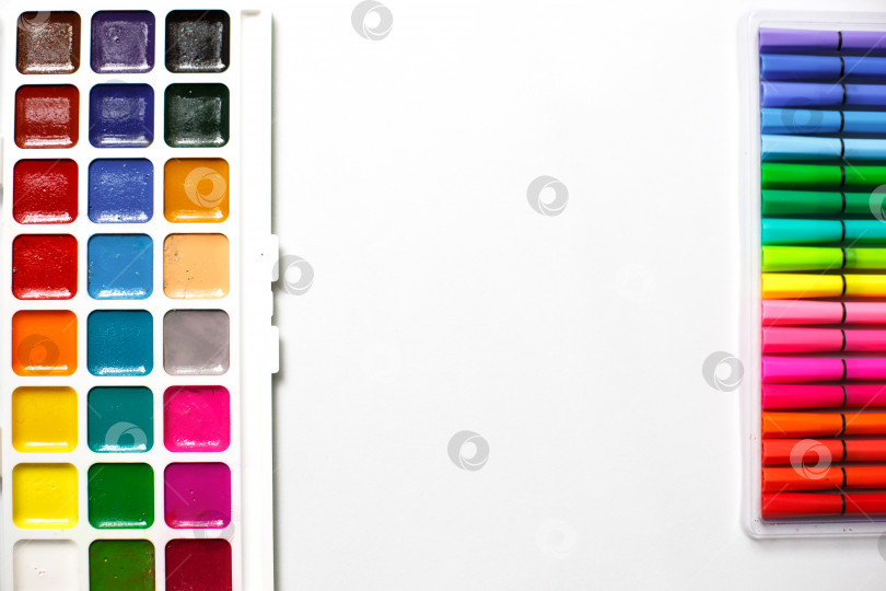 Скачать Палитра цветных акварелей с кистями и маркерами на белом фоне с пространством для текста. фотосток Ozero