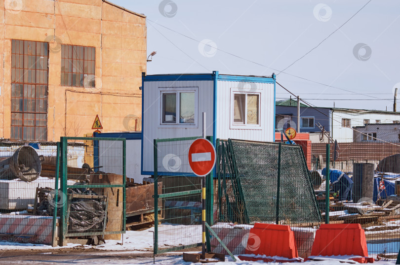 Скачать Въезд на строительную площадку с постом охраны, ограждением, воротами, запрещающим знаком. фотосток Ozero