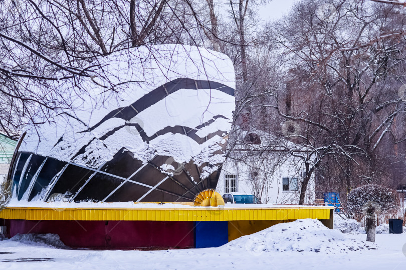 Скачать Снег на куполе крыши летней концертной площадки в пустынном зимнем парке. фотосток Ozero