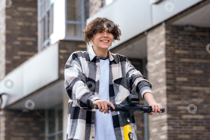 Скачать молодой человек на электрическом скутере едет по улице фотосток Ozero