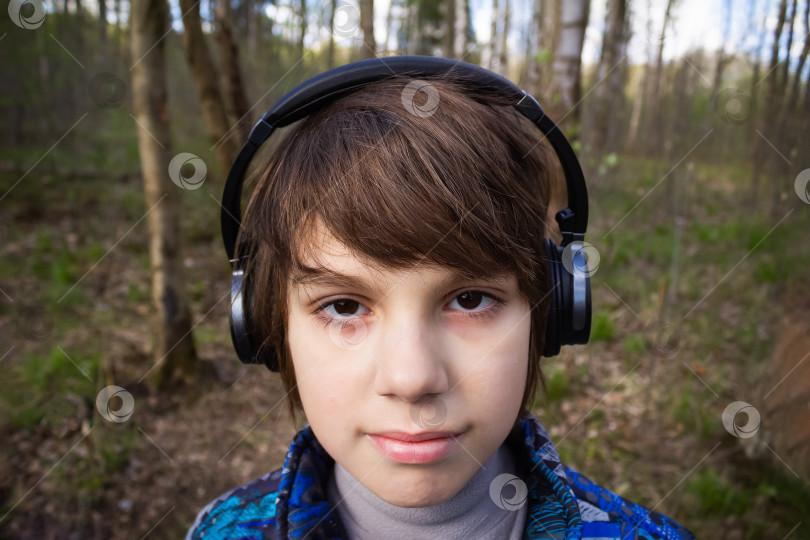 Скачать Портрет мальчика в наушниках на фоне деревьев фотосток Ozero
