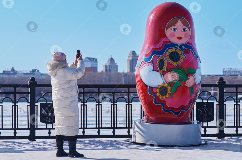 Скачать Большая матрешка на заснеженной зимней набережной реки Амур. фотосток Ozero