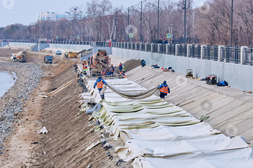 Скачать Берегоукрепительные работы на участке реконструкции городской набережной. Рабочие заливают бетонные конструкции. фотосток Ozero