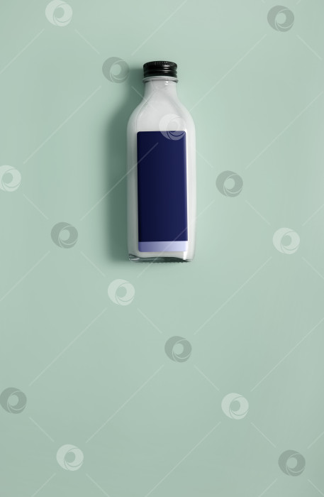 Скачать Макет: Стеклянная бутылка с белой жидкостью (молоком, сливками, соусом), выделенная на цветном фоне фотосток Ozero