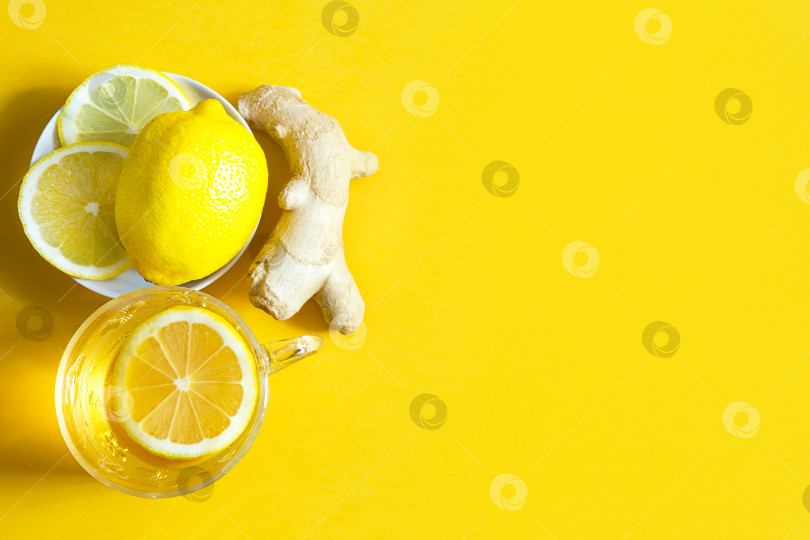 Скачать Целебный чай в чашке, имбирь, лимон- укрепляют иммунитет в холодное время года и копируют пространство, лист для заметок. Витаминный напиток для здоровья и ингредиенты на желтом светящемся фоне. фотосток Ozero