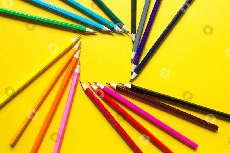 Скачать Набор разноцветных карандашей на желтом фоне выложен по кругу в форме квадрата. Копировальное пространство, рамка. Снова в школу, художник, уроки рисования. Канцелярские принадлежности для творчества, рисования фотосток Ozero