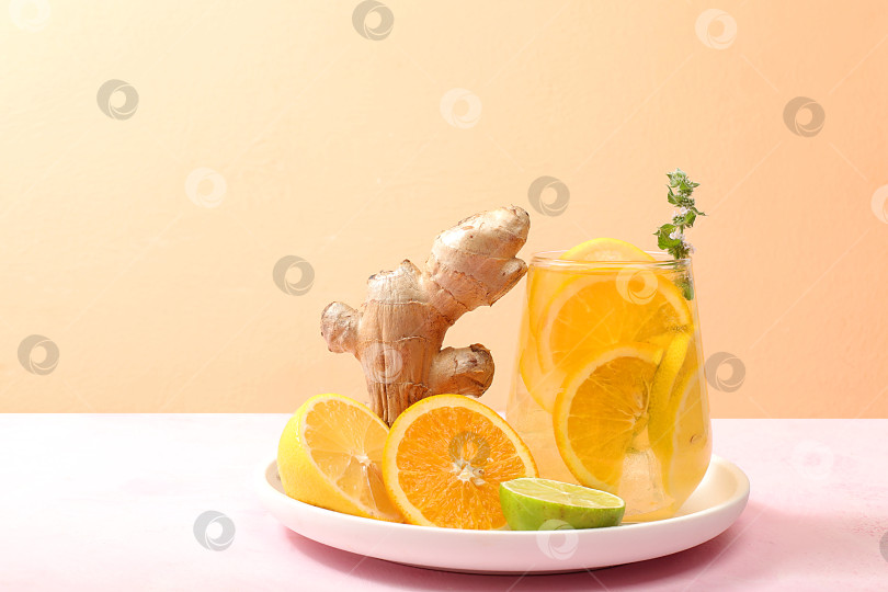 Скачать Детокс-напиток с лимоном, мятой, лаймом, имбирем и апельсином на темном столе, коктейль улучшает обмен веществ и способствует похудению, минимальная концепция здорового образа жизни, фотосток Ozero