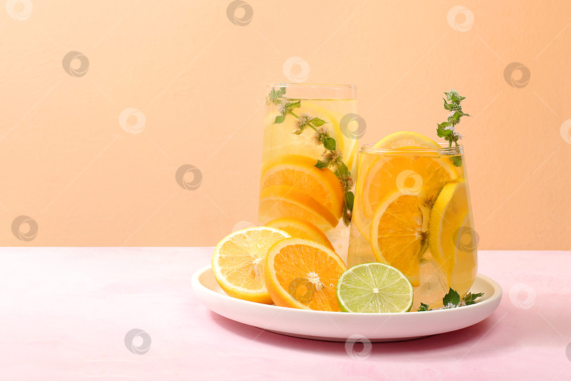 Скачать Детокс-напиток с лимоном, мятой, лаймом и апельсином на легком столе, коктейль улучшает обмен веществ и способствует похудению, концепция здорового образа жизни, фотосток Ozero