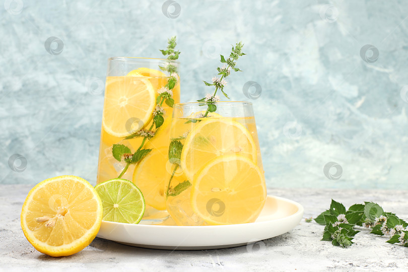 Скачать Детокс-напиток с лимоном, мятой, лаймом и апельсином на легком столе, коктейль улучшает обмен веществ и способствует похудению, концепция здорового образа жизни, фотосток Ozero