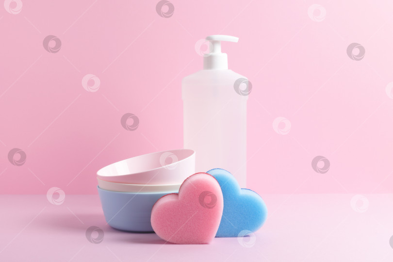 Скачать Тарелки, губки для посуды в виде сердечек и моющее средство на розовом фоне. фотосток Ozero