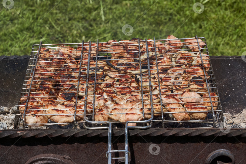 Скачать Мясо обжаривается над раскаленными углями в жаровне на решетке. Барбекю будет приготовлено на углях. фотосток Ozero