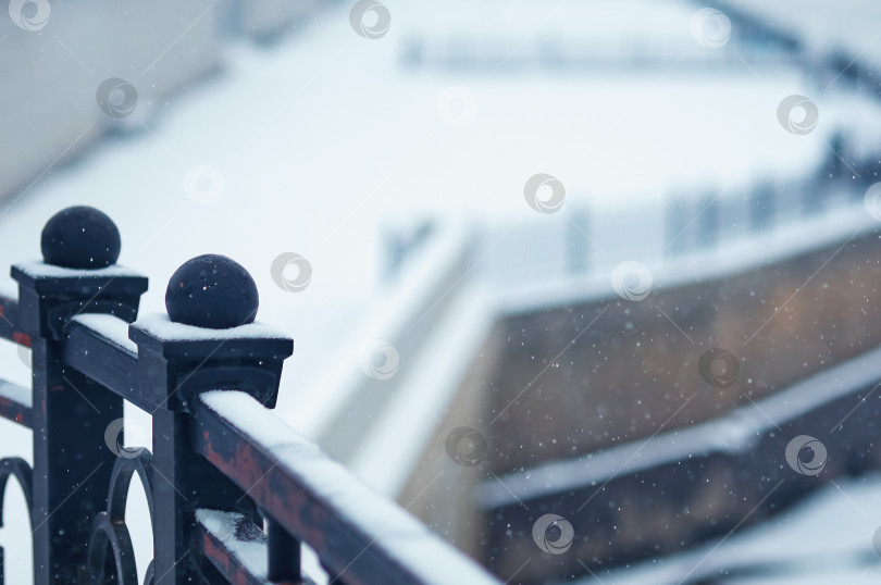 Скачать White snow on the black metal railings of the Amur river embankment on a winter morning. The texture of a natural phenomenon. Close up. Selective focus фотосток Ozero