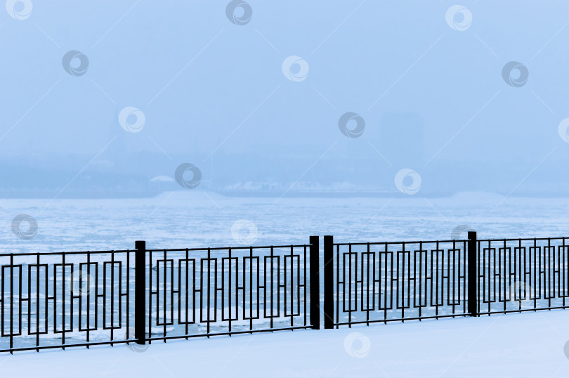 Скачать White frost on the black metal railings of the Amur river embankment on a winter morning. фотосток Ozero