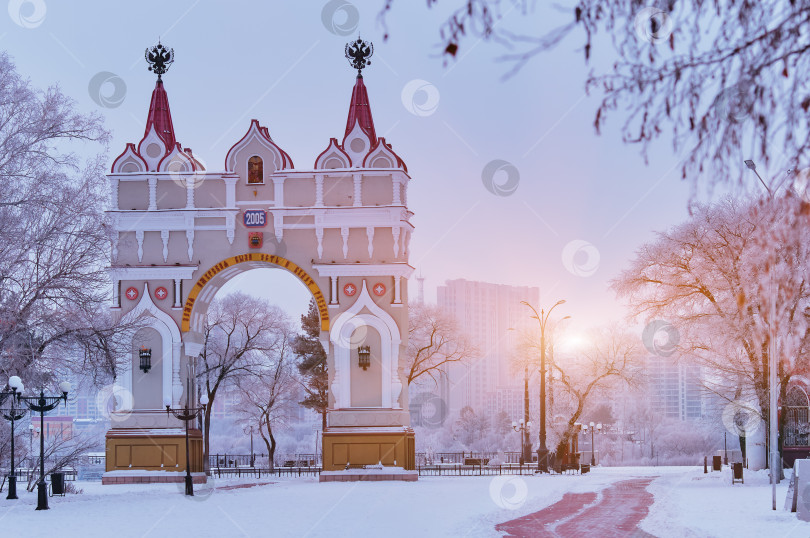 Скачать Arc de Triomphe on a winter morning. The inscription is in Russian, the Amur land was and will be Russian. Snow covered trees at sunrise. Landmark of the city of Blagoveshchensk, Russia. фотосток Ozero