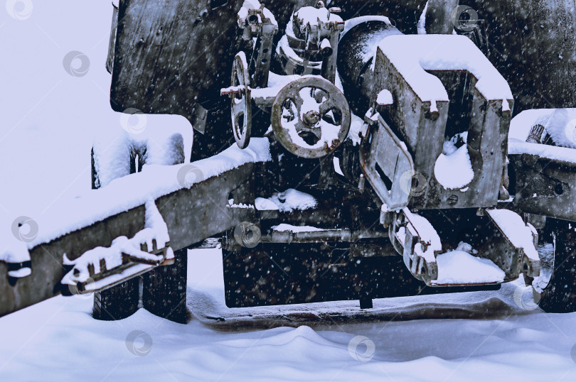 Скачать Fragment of an artillery gun from the Second World War. Snowing. Mechanisms of control and aiming. фотосток Ozero