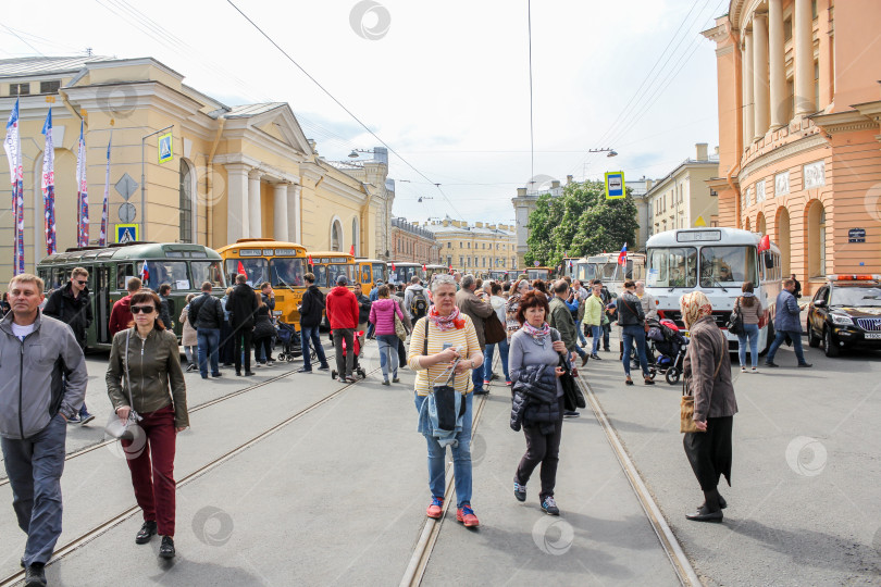 Скачать Толпа посетителей на выставке между автобусами. фотосток Ozero