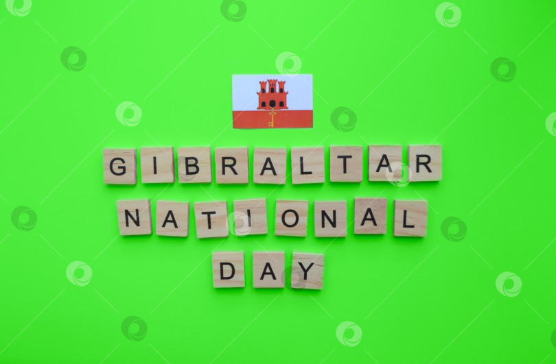 Скачать September 10, Gibraltar National Day, flag of Gibraltar, minimalistic banner with wooden letters on a green background фотосток Ozero