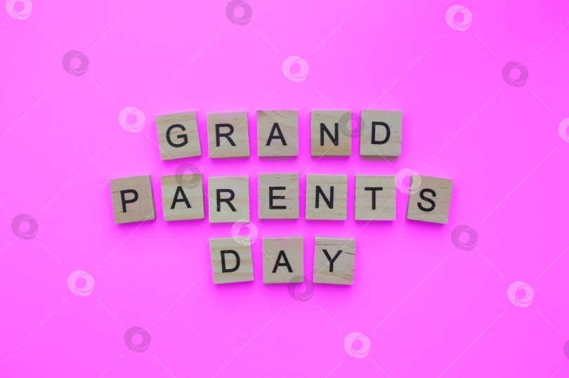 Скачать September 10, National Grandparents Day, minimalistic banner with the inscription in wooden letters on a pink background фотосток Ozero