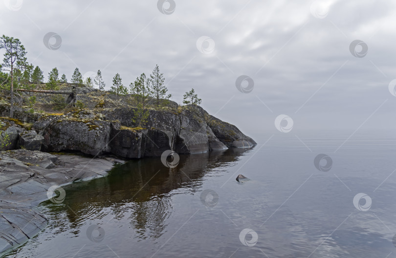 Скачать A steep granite cape in the haze. Ladoga skerries, Karelia, Russia. фотосток Ozero