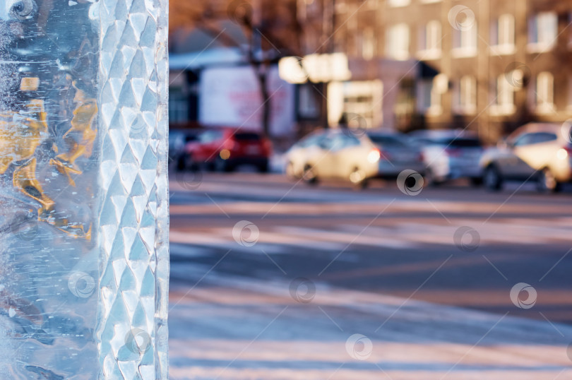 Скачать A fragment of an icy New Year's figure on a city street in the evening. Road with vehicles in heavy blur in the background. фотосток Ozero