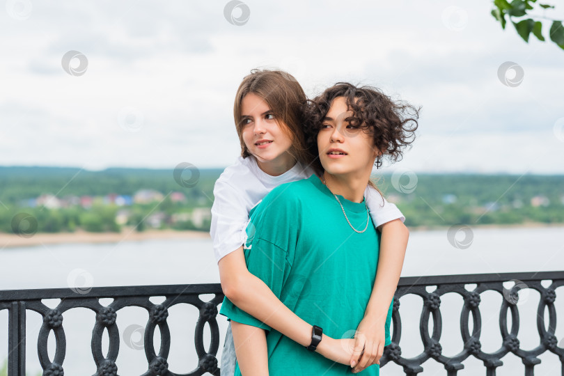 Скачать couple of young people hugging against a blurred river landscape фотосток Ozero