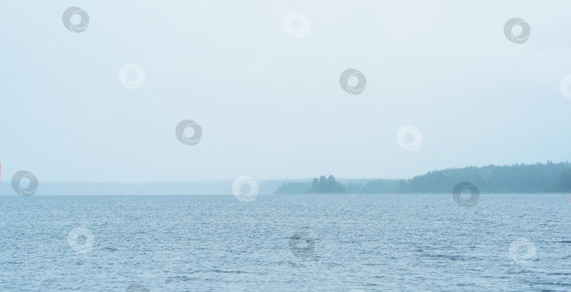 Скачать foggy natural waterscape, downpour over a wide body of water фотосток Ozero