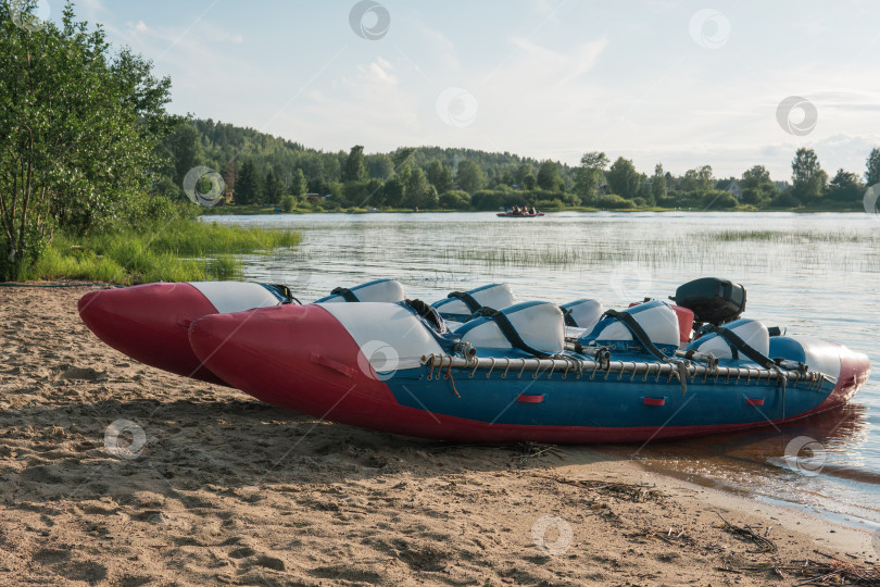 Скачать inflatable raft-catamaran for whitewater sports is moored on the river bank фотосток Ozero