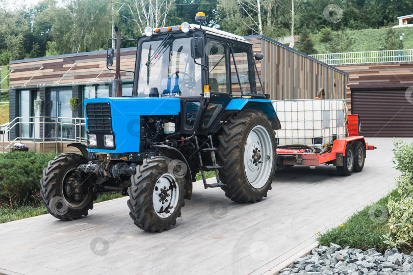 Скачать wheeled tractor with irrigation tanks on a trailer for maintenance of urban green spaces фотосток Ozero