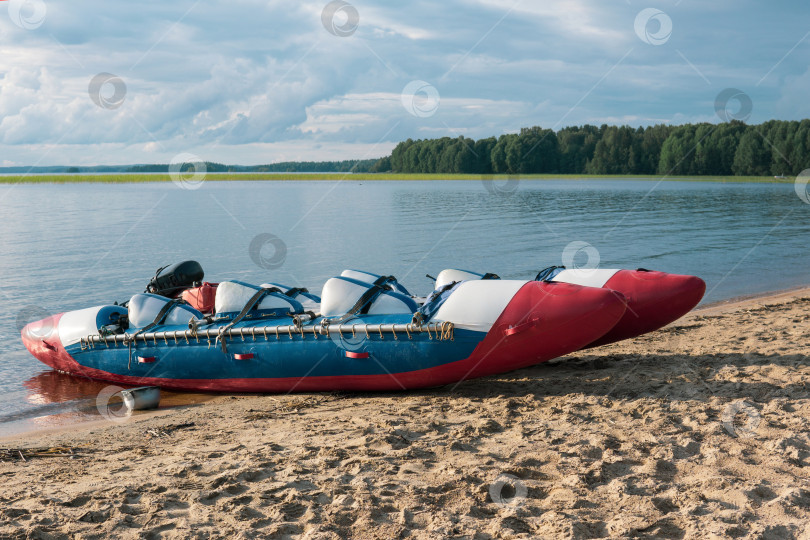 Скачать inflatable raft-catamaran for whitewater sports is moored on the lake shore фотосток Ozero