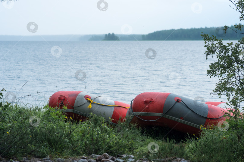 Скачать inflatable rafts is moored on the lake shore on a rainy day фотосток Ozero