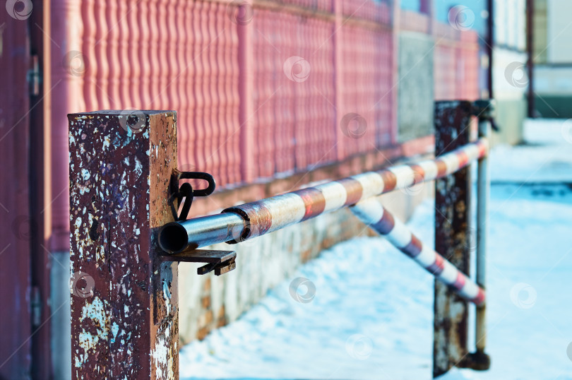 Скачать Old rusty barrier on a winter morning. Selective focus. Snow and fence in strong blur фотосток Ozero