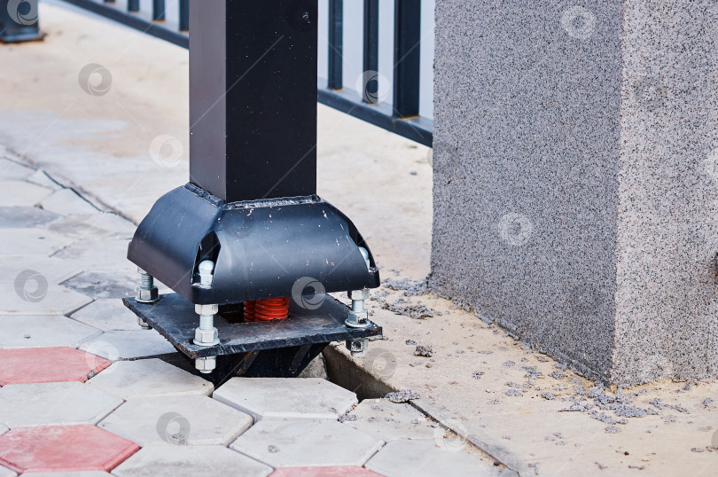 Скачать The base of the street lamp support on the embankment. Red cable corrugations and bolted construction. Installation of electrical equipment during construction. фотосток Ozero