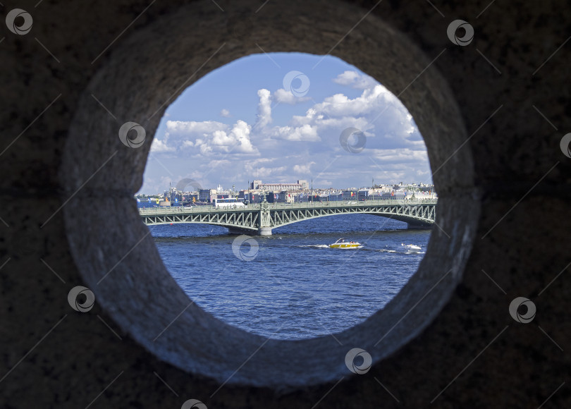 Скачать View of the Trinity Bridge through the round window of the Peter and Paul Fortress. фотосток Ozero
