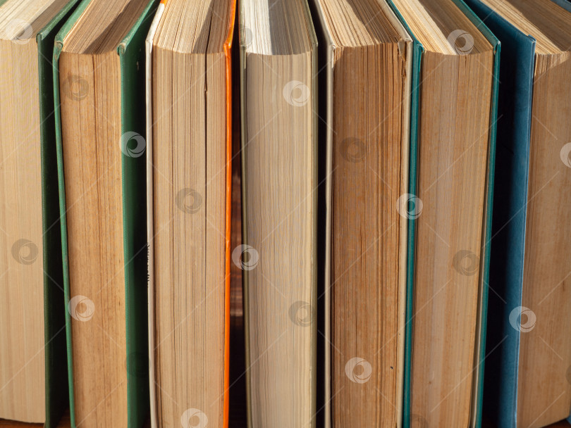 Скачать Hardcover books on a wooden table top view. Back to school background фотосток Ozero