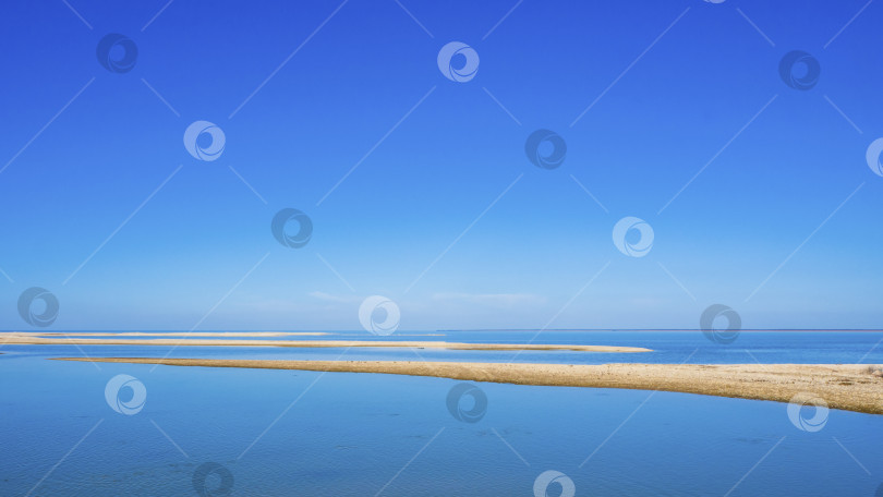 Скачать Blue sky over the sea lagoon with sandbanks and bays. blue sky, sea with azure water and sand. Picturesque view of the sea with wildlife against a clear blue sky. seascape фотосток Ozero
