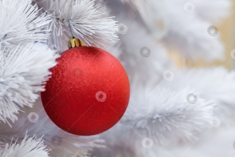 Скачать Close up view of a white artificial Christmas tree decorated with red balls фотосток Ozero