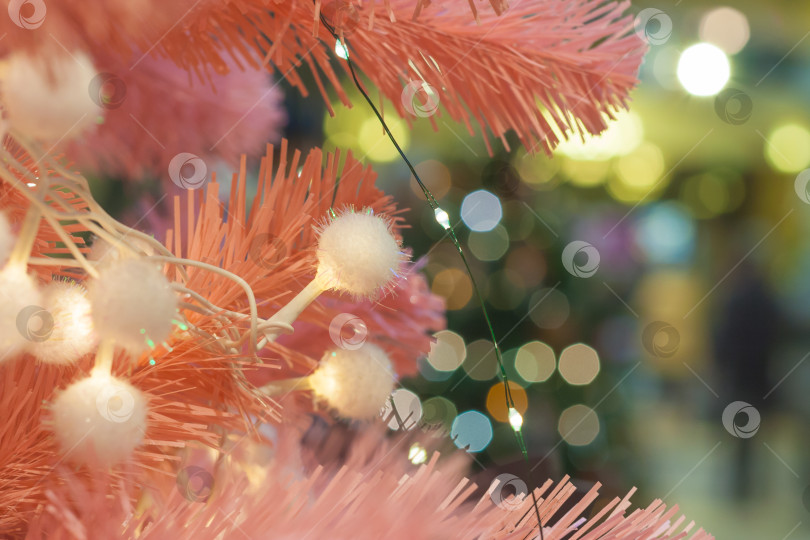 Скачать Close up view on a pink Christmas tree with garland фотосток Ozero