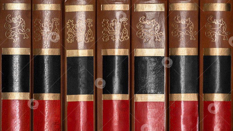 Скачать A row of antique books with leather hardcover as background, texture фотосток Ozero