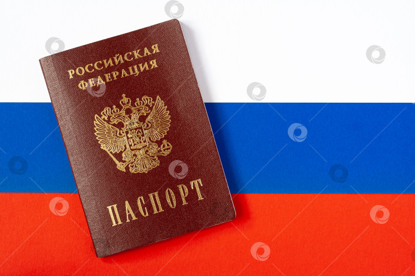 Скачать Passport of a citizen of the Russian Federation, on a background of the national flag (copy space) фотосток Ozero