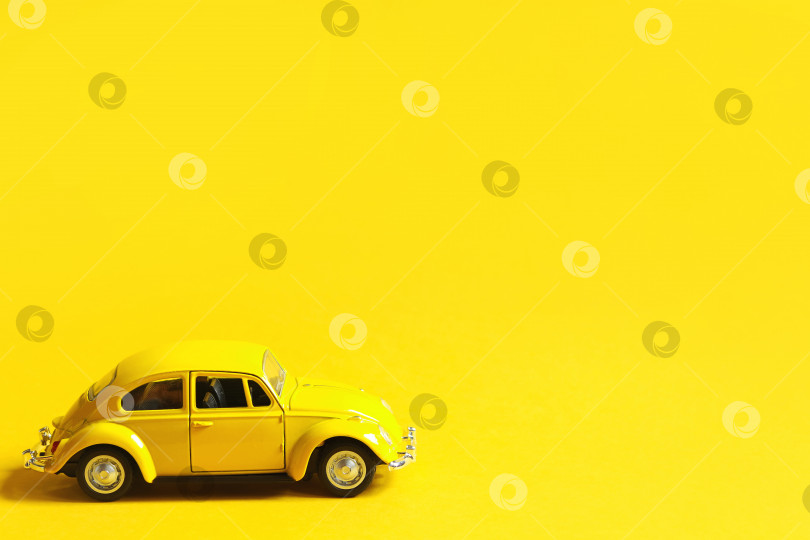 Скачать Желтая игрушечная машинка на цветном фоне. Пространство для копирования. Детская игрушка, такси, ретро-автомобиль, лето, путешествия. фотосток Ozero